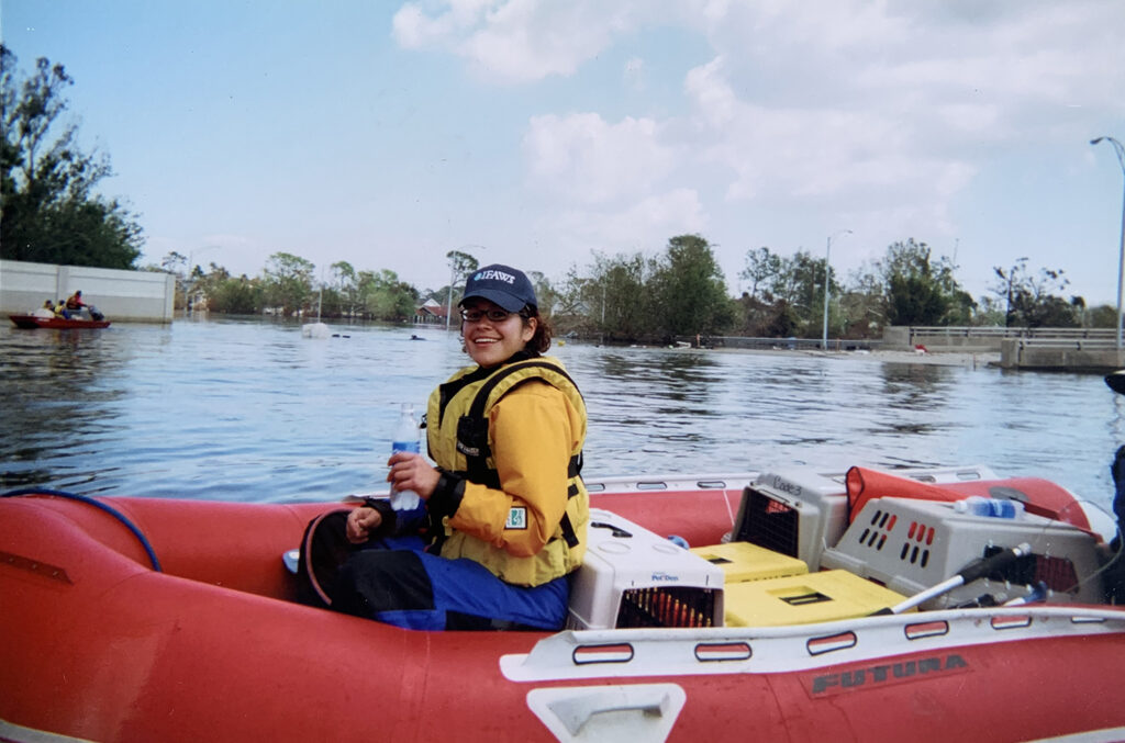 Allison on a raft wearing a life jacket, with crates behind her.