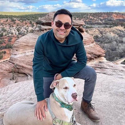 José Ocaño with tan and white dog atop a scenic mesa