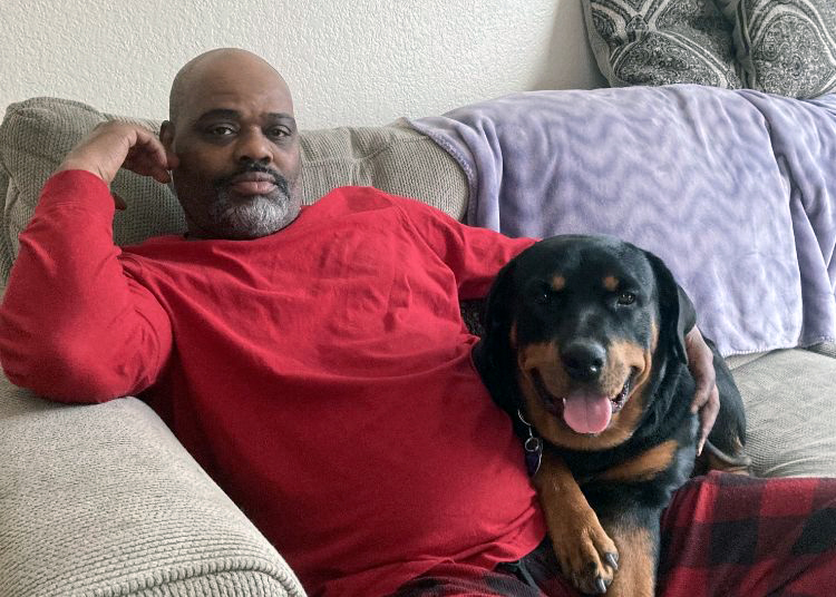 Marvin Adams cuddles with his dog, Coco