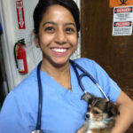 Photo of Chumkee in blue scrubs holding a small dog