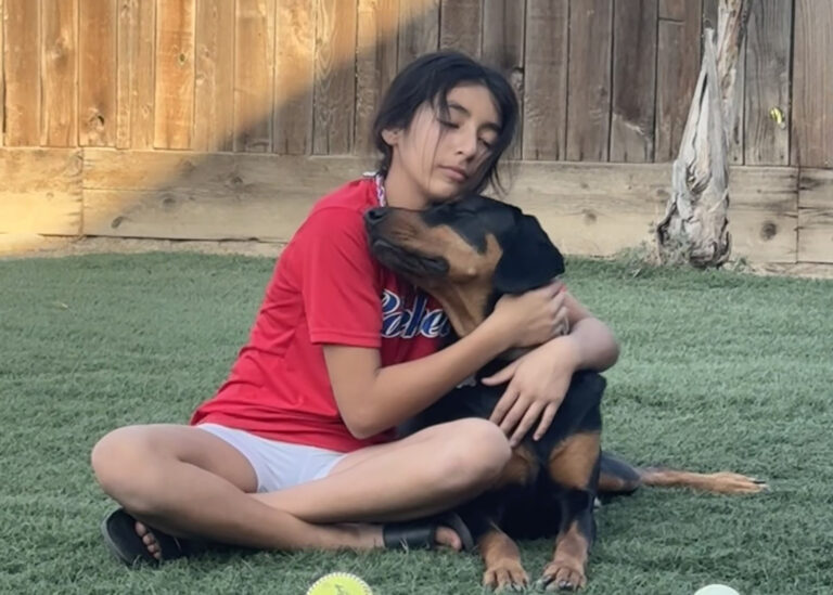 Ivy Ruiz's daughter Xani hugs her dog Renzo